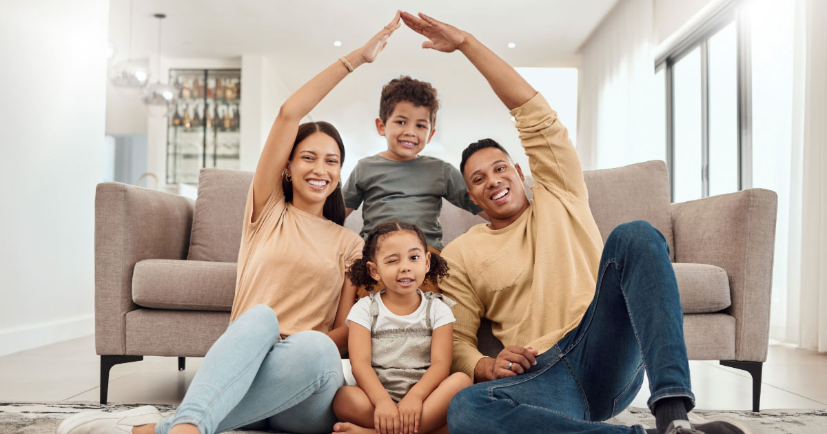 Dad and mom with two children sitting in living room of their home