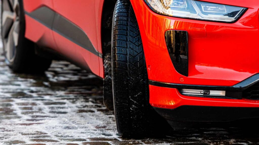 Red electric car in a brick driveway