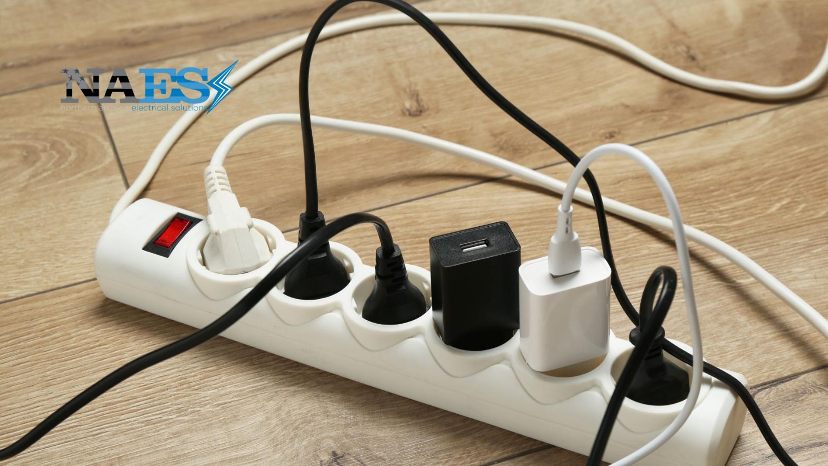 Overloaded power strip and electrical outlets with multiple plugged-in devices creating a potential fire hazard